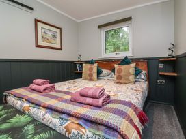 A bedroom with a bed and decorative pillows at Robins Nest Lodge South Molton