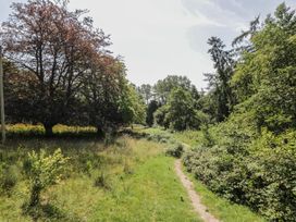 A path through trees and grass at Robins Nest Lodge South Molton