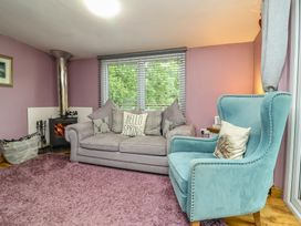 A living room with a sofa and armchair at Hedgehogs Lodge in South Molton