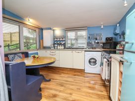 A kitchen with appliances and a table at Hedgehogs Lodge in South Molton