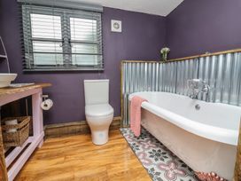 A bathroom with a toilet, bathtub, and sink at Hedgehogs Lodge in South Molton