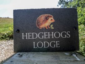 A sign for Hedgehogs Lodge with a hedgehog illustration at Hedgehogs Lodge in South Molton