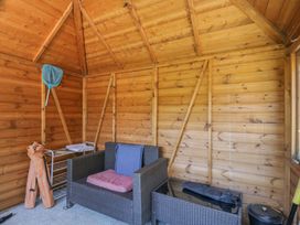 A snug with wooden walls and seating at Hedgehogs Lodge in South Molton