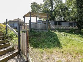 A building with a deck and staircase at Hedgehogs Lodge in South Molton
