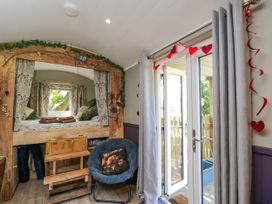 A bedroom with a bed and chair at Valley View Shepherd's Hut South Molton