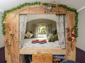 A bedroom with a bed and window at Valley View Shepherd's Hut in South Molton