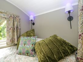 A bedroom with pillows and lamps at Valley View Shepherd's Hut South Molton