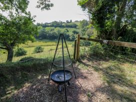 A fire pit with a view of hills at Valley View Shepherd's Hut in South Molton