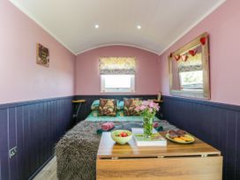 A bedroom with a bed and small table at Hares Hideaway Shepherd's Hut South Molton