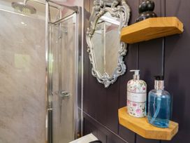 A bathroom with a shower and toiletries at Hares Hideaway Shepherd's Hut in South Molton