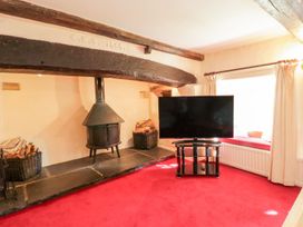 A living room with a fireplace and television at The Farmhouse in Keswick