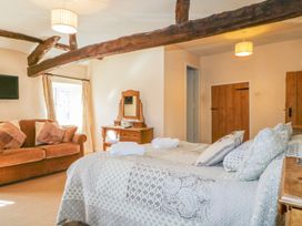 A bedroom with a bed and sofa at The Farmhouse in Keswick