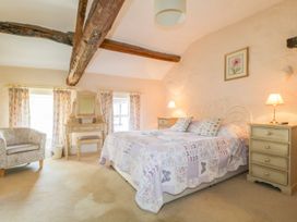 A bedroom with a bed and armchair at The Farmhouse in Keswick