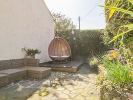 A garden with outdoor seating and a hanging chair at The Farmhouse in Keswick