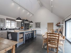 A kitchen with an island and dining area at Wood Meadow in Helston