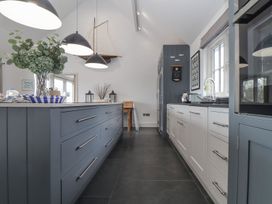 A kitchen with a central island and cabinets at Wood Meadow in Helston