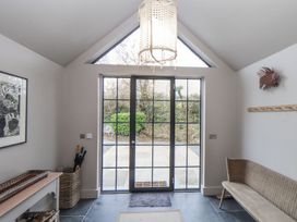 A hallway with a door and bench at Wood Meadow in Helston