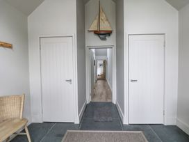 A hallway with two doors and a decorative sailboat at Wood Meadow in Helston