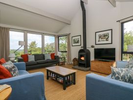 A living room with a wood stove and a television at Wood Meadow in Helston