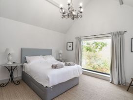 A bedroom with a bed and window at Wood Meadow in Helston
