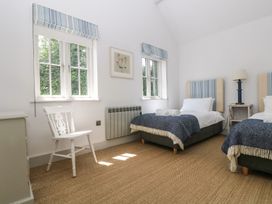 A bedroom with two beds and a chair at Wood Meadow Helston