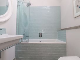 A bathroom with a sink, bathtub, shower and mirror at Wood Meadow in Helston