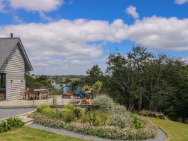 An outdoor patio with a dining table and chairs at Wood Meadow in Helston