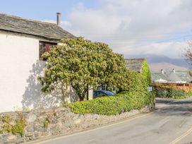 A house with trees and a stone wall at Farmhouse Cottage in Keswick