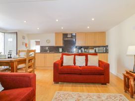 A living room with a sofa and dining table at Farmhouse Cottage in Keswick