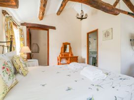 A bedroom with a bed and dressing table at Farmhouse Cottage in Keswick