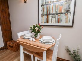 A dining table set with flowers and plates at Wren's Nest in Lealholm