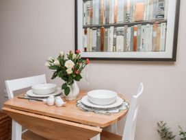 A dining room with a table set for two and a vase of flowers at Wren's Nest in Lealholm
