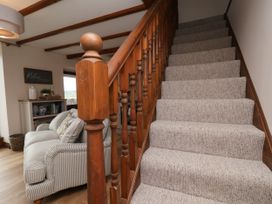 A staircase leading to another floor with a sofa in the living room at Wren's Nest Lealholm