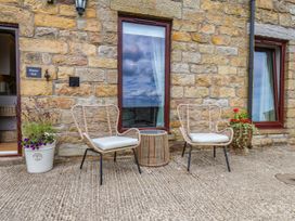 Two chairs and a small table in an outdoor sitting area at Wren's Nest in Lealholm