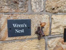 A plaque with Wren's Nest and a bird faucet at Wren's Nest in Lealholm