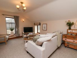 A living room with a sofa and television at Swallow Cottage in Lealholm