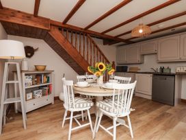 A kitchen with a dining table and chairs at Swallow Cottage in Lealholm