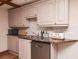 A kitchen with cabinets, sink, and appliances at Swallow Cottage in Lealholm
