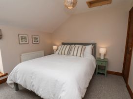 A bedroom with a bed and bedside table at Swallow Cottage in Lealholm