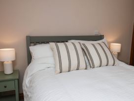 A bedroom with a bed and bedside lamps at Swallow Cottage in Lealholm