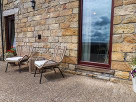 An outdoor area with two chairs and a table at Swallow Cottage in Lealholm