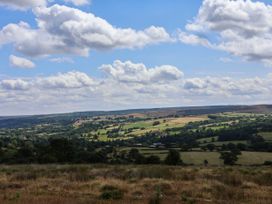 A landscape view of fields and hills under a blue sky at Swallow Cottage in Lealholm
