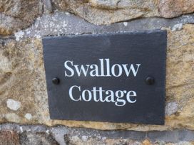 A slate sign reading Swallow Cottage at Swallow Cottage in Lealholm