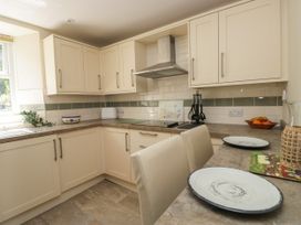 A kitchen with cabinets and stove at Bobbin Nook