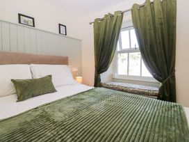 A bedroom with a bed and window seat at Bobbin Nook