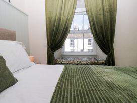 A bedroom with a bed and window seat at Bobbin Nook