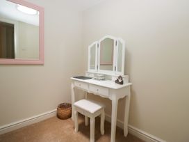 A dressing room with a vanity table and mirror at Bobbin Nook