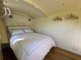 A bedroom with a bed and hangers at The Orchard in Ringstead