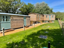Three wooden caravans in an outdoor area at The Orchard in Ringstead