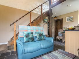 A living room with a sofa and a staircase at Ty Gwenno in Criccieth